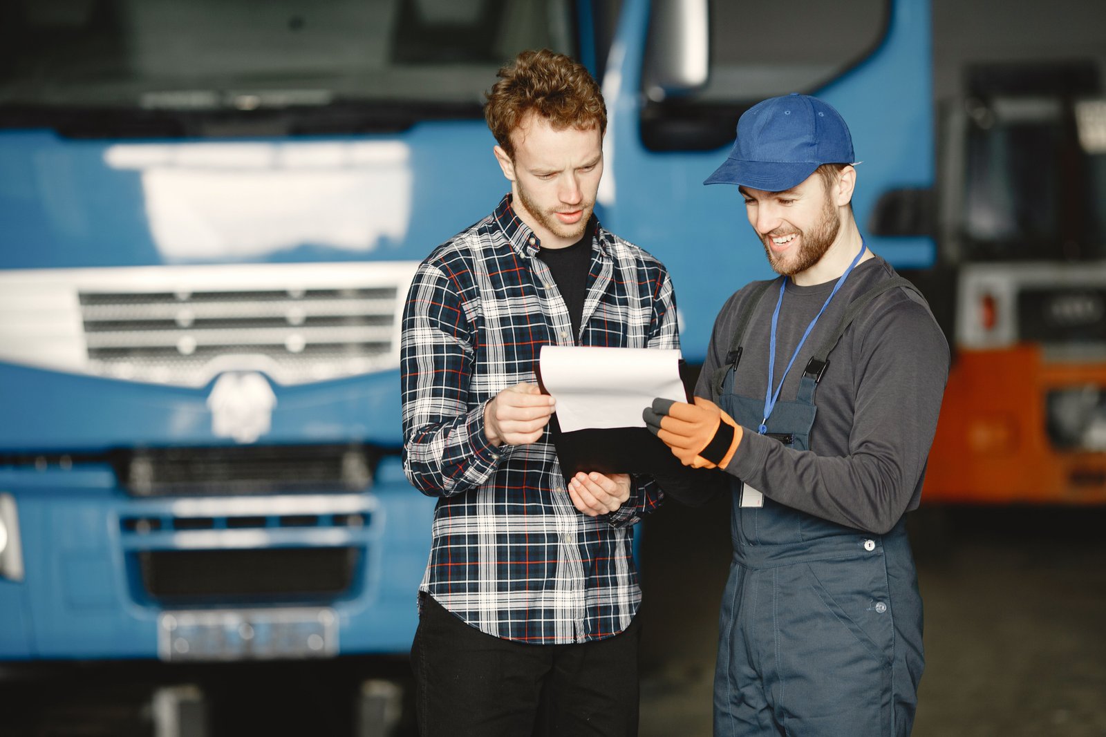 Two professionals discussing vehicle service requirements